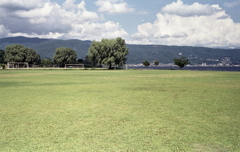 風に棚引く湖畔の木々