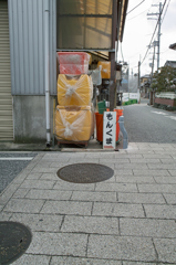 何？
