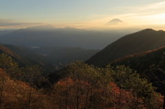 朝色に輝く紅葉と山並み