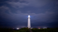 灯台と雲多い星空