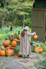 Little girl playing with a pumpkin ...