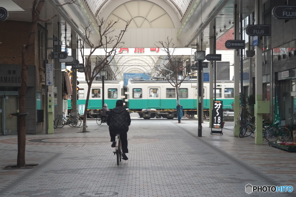 商店街を駆け抜ける電車