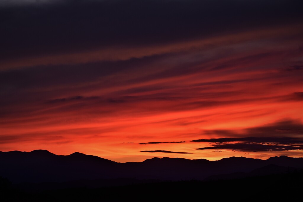 家の窓から十枚山と夕陽