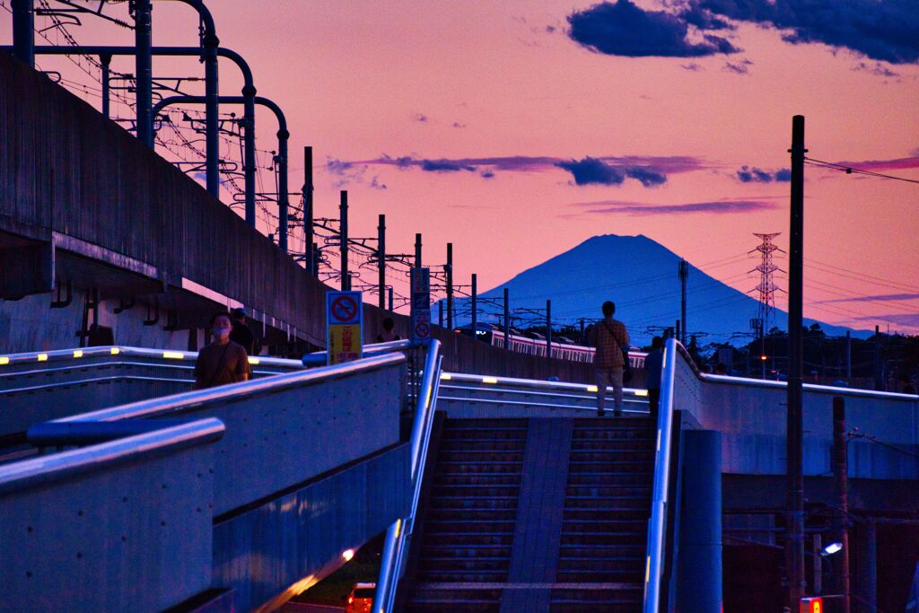 台風一過の夕景に富士山に立ち尽くす人