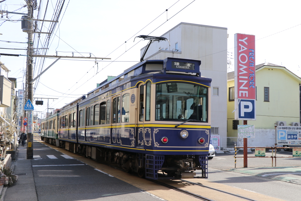 道路の真ん中を走行する10形江ノ電車両
