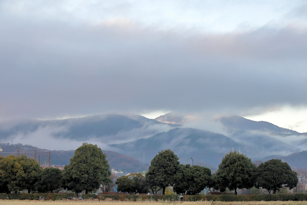山に掛かる霧の合間に夕陽