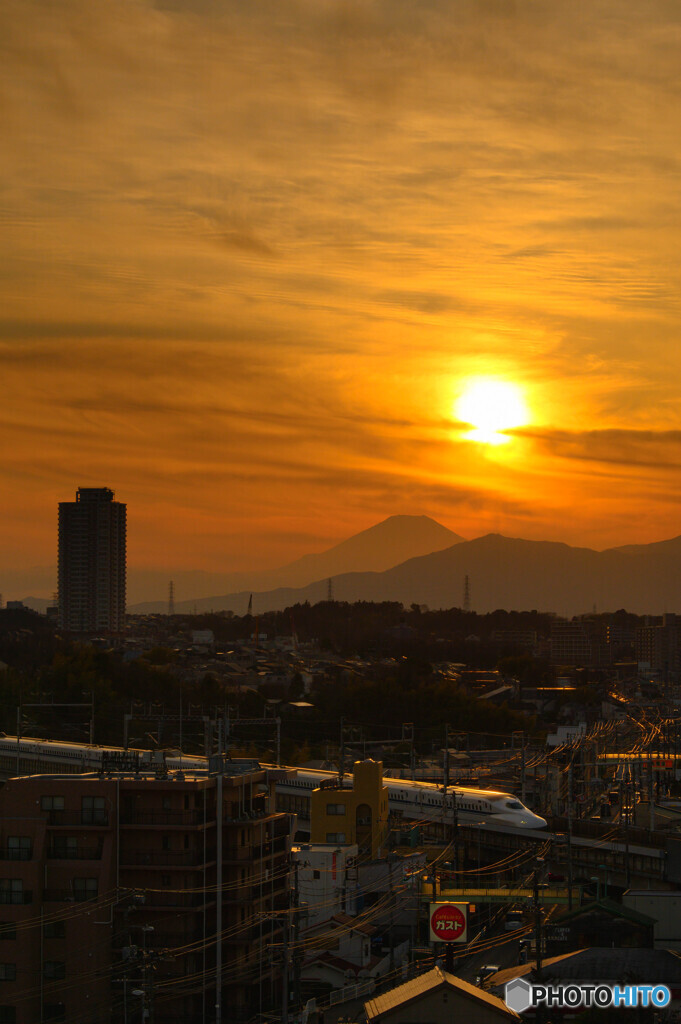 夕陽を浴びる街並みと新幹線