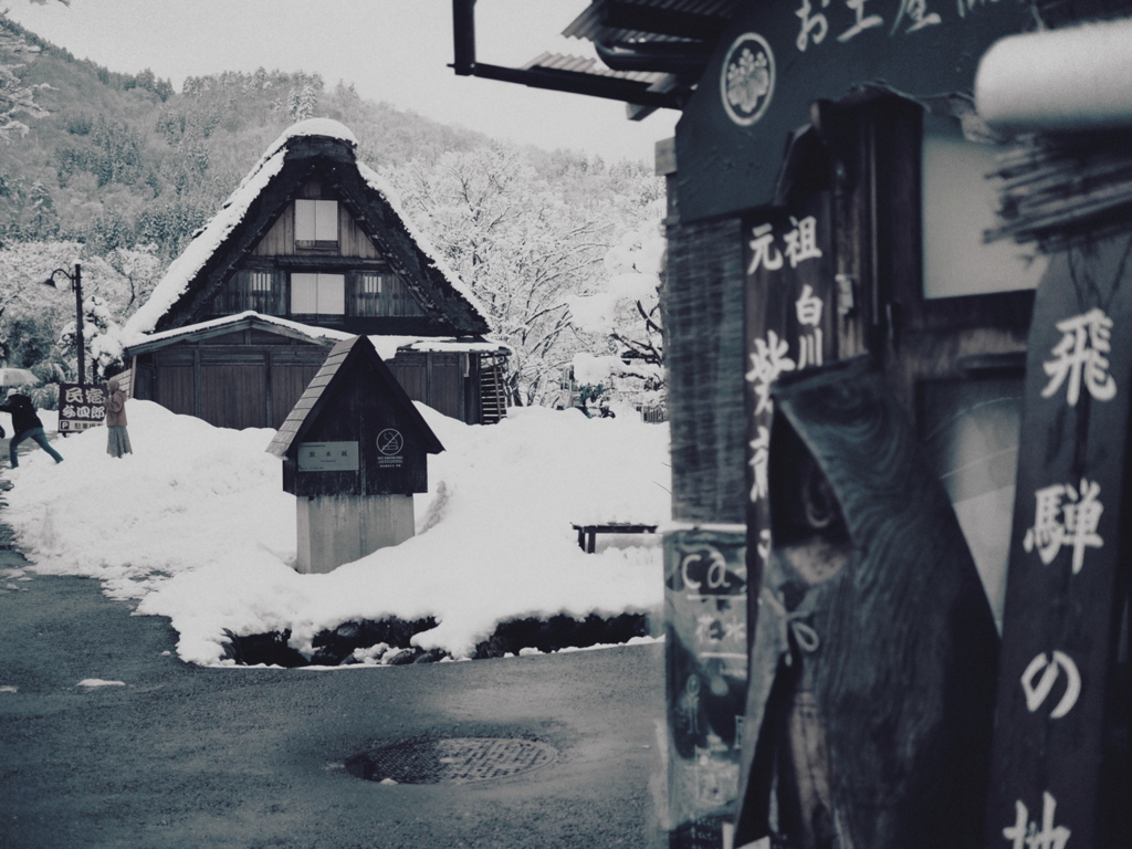 雪と合掌造りの古民家と地蔵