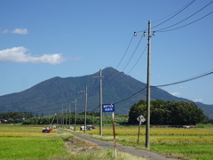 筑波山と稲穂の収穫作業