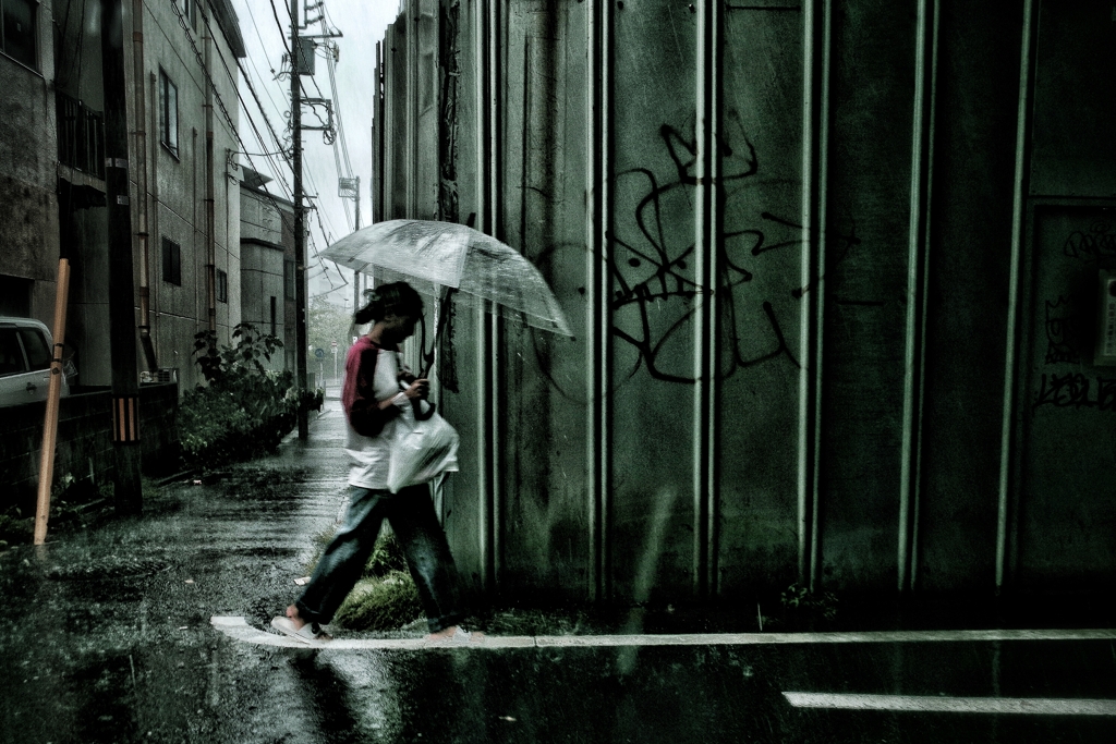 大雨の中を歩く外国人女性