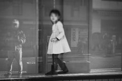 開業前の店舗のショーウィンドウに入って遊ぶ女の子