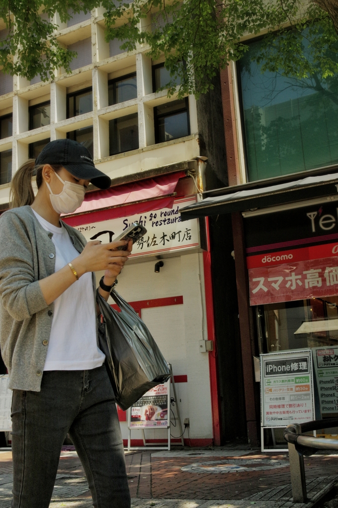 スマホしながら歩く女