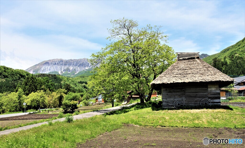 大山と茅葺きの小屋