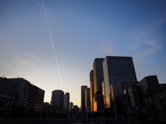 夕焼けとビルと飛行機雲