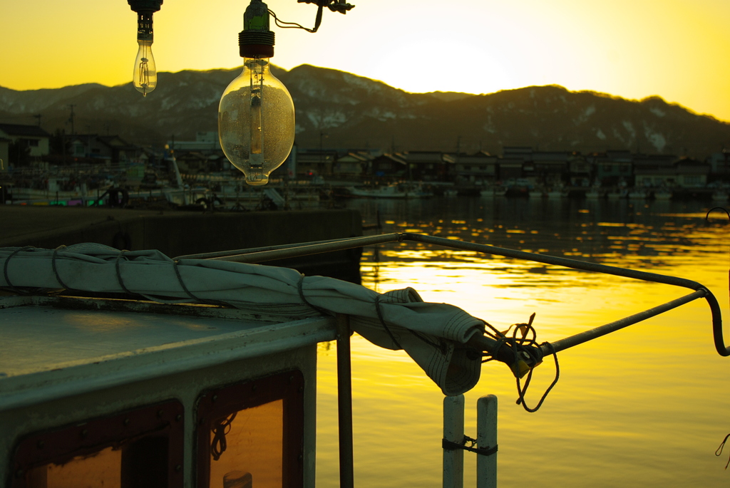 イカ釣り漁船と夕日