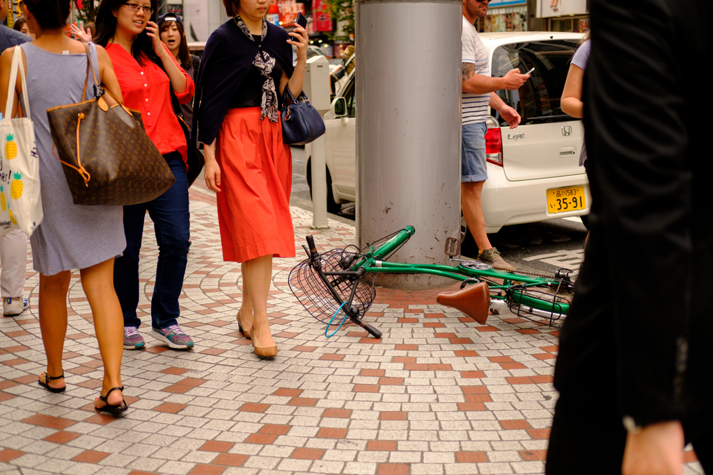 緑色の自転車が横転して歩行者の邪魔になる