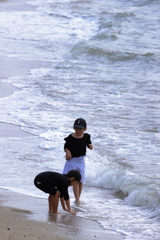 浜辺で波と戯れる