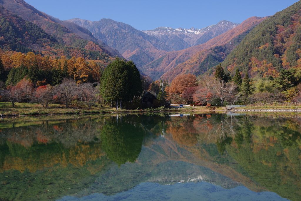 秋の山々を映す池