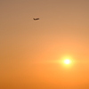 夕日と空へと向か飛行機