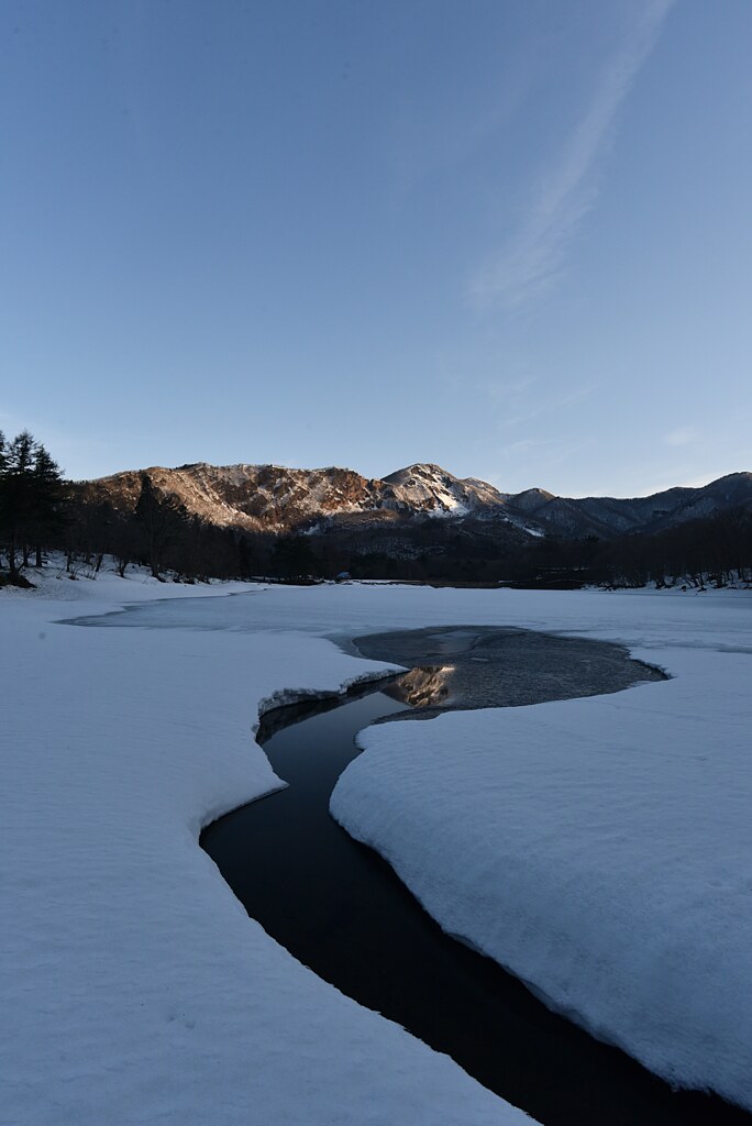 朝日に照らされた雪解けの山