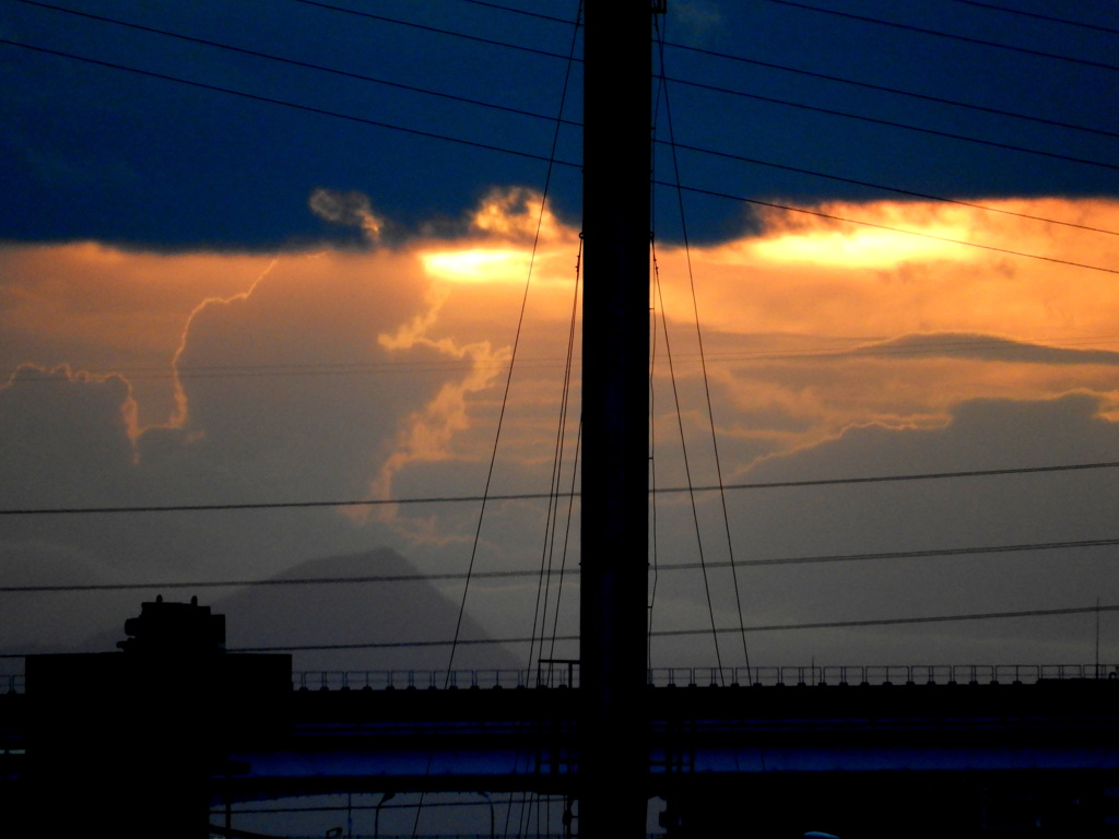 雲の下から降りてきそうな夕日であるが