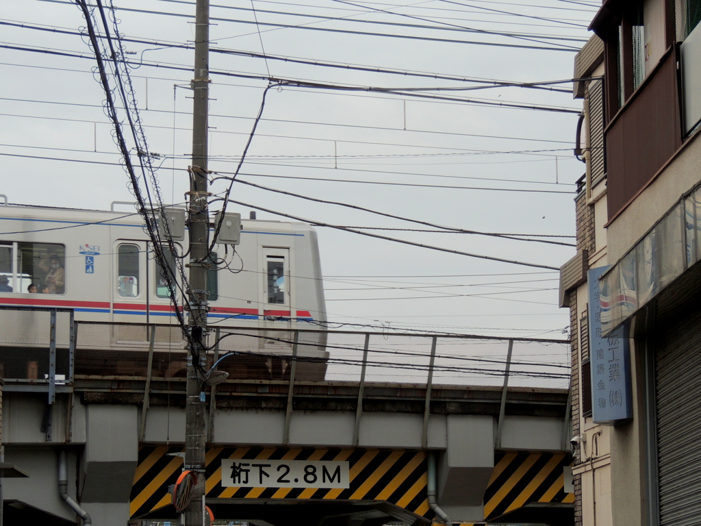 路地から見える愛染川通り上の京成線