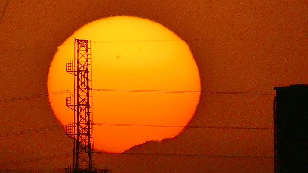 遠くの鉄塔の右小金沢山の夕日