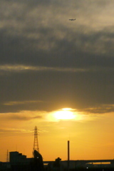 隅田川の煙突の上の雲から降りる夕日