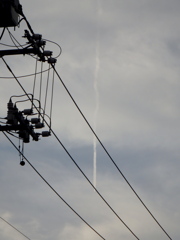 町屋の電線の飛行機雲