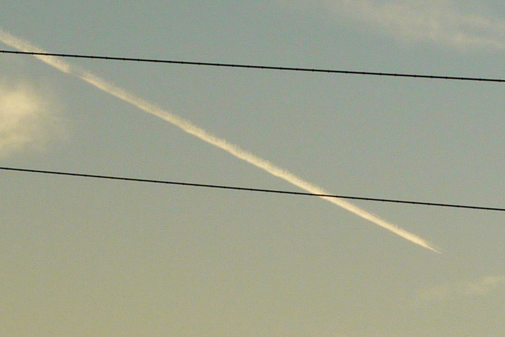 西新井橋の電線を横切る飛行機雲
