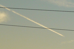 西新井橋の電線を横切る飛行機雲
