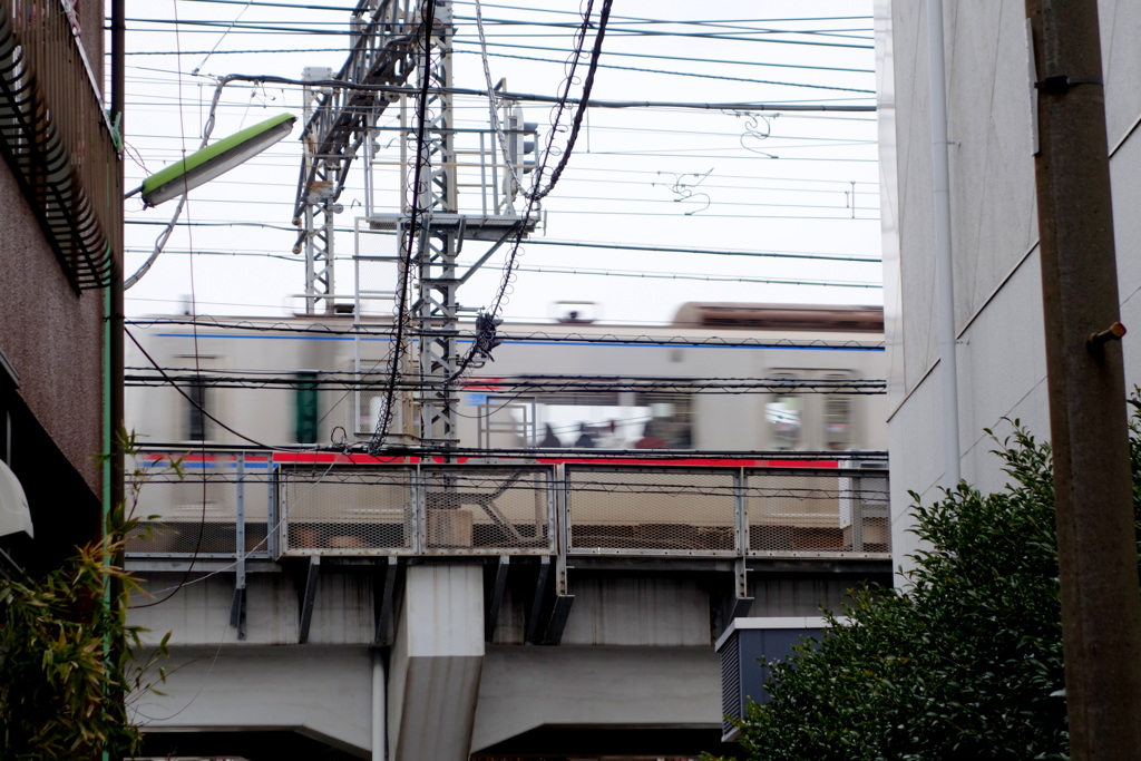 荒川7丁目小踏切の路地から愛染川通り効果を走る京成本線町屋駅へ