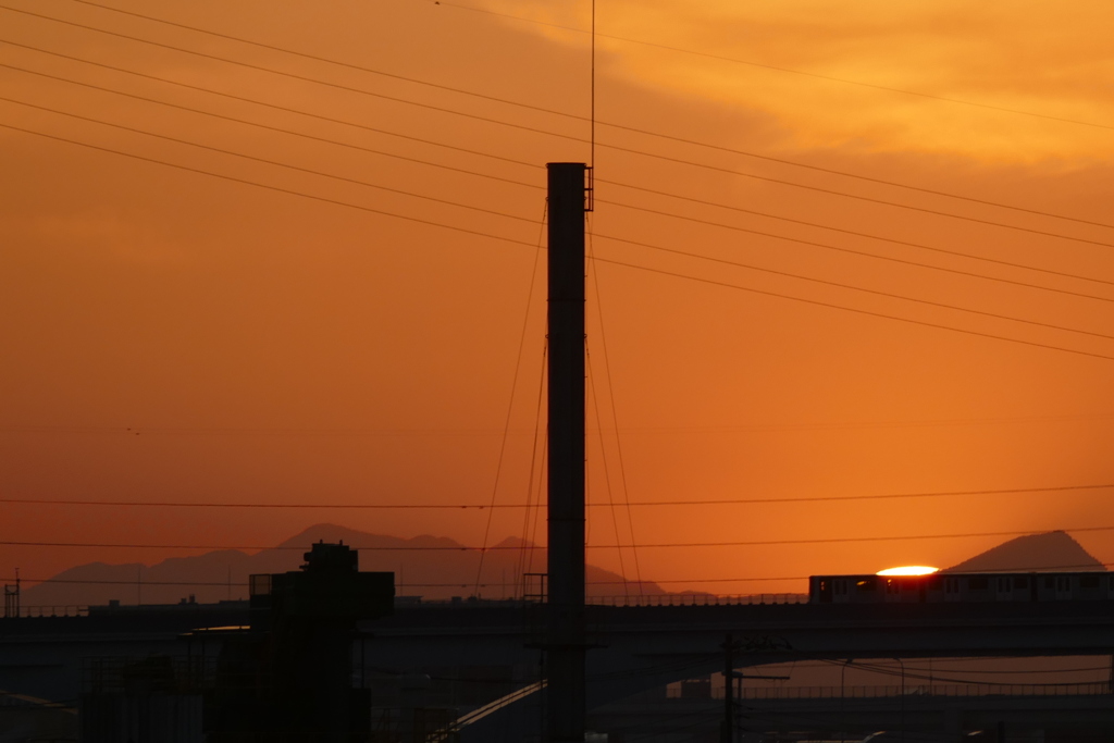 小台駅に入る夕日の前のシルエット