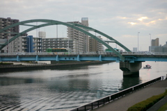 夕方の尾竹橋の隅田川の船の波紋