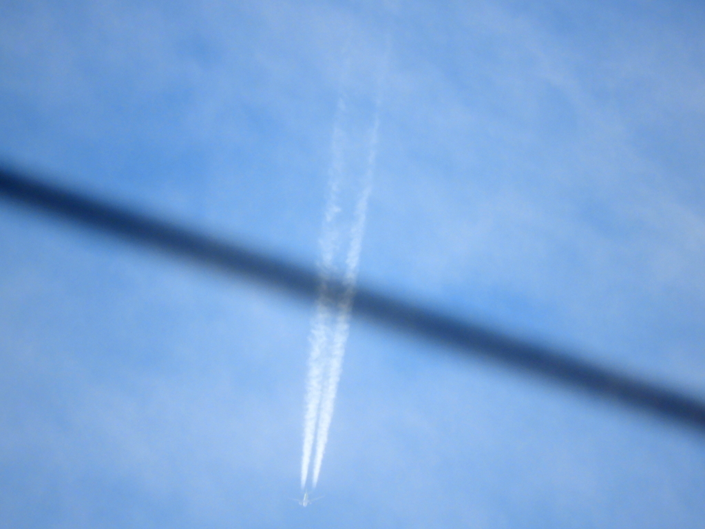 千住緑町の京成線の高架の電線を横切る飛行機雲
