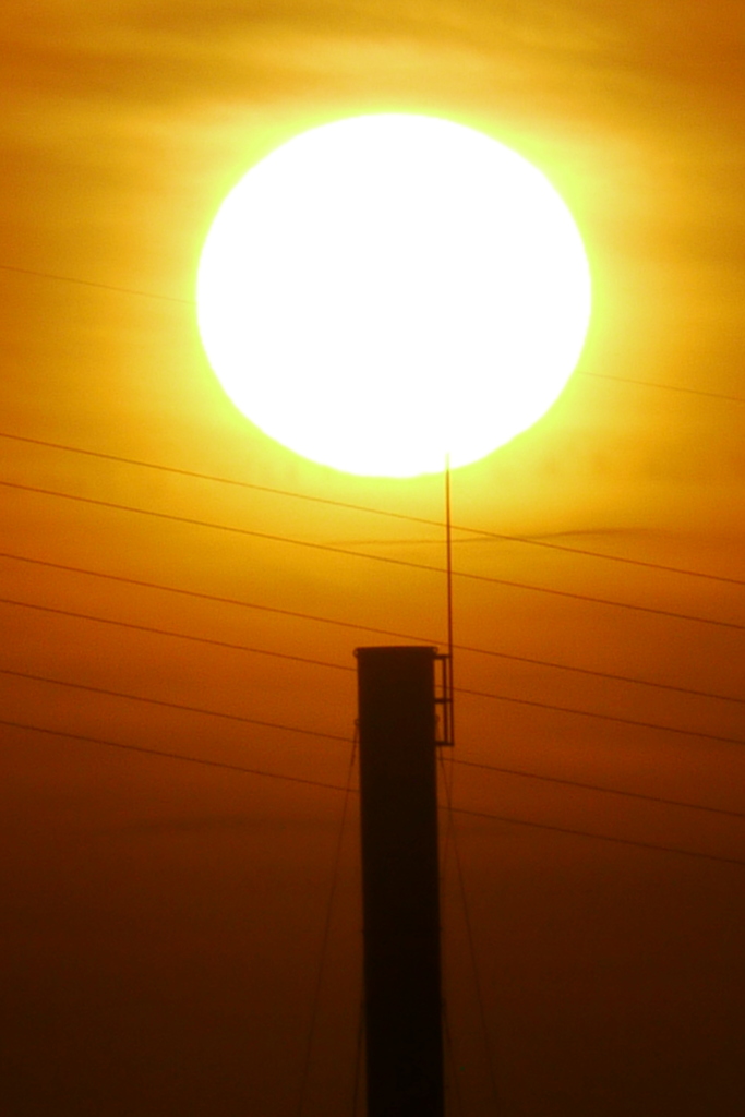 隅田川の煙突の上の大きな夕日