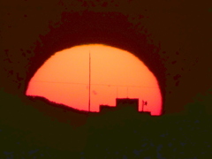 富士山の裾のに沈む黒点の見える夕日