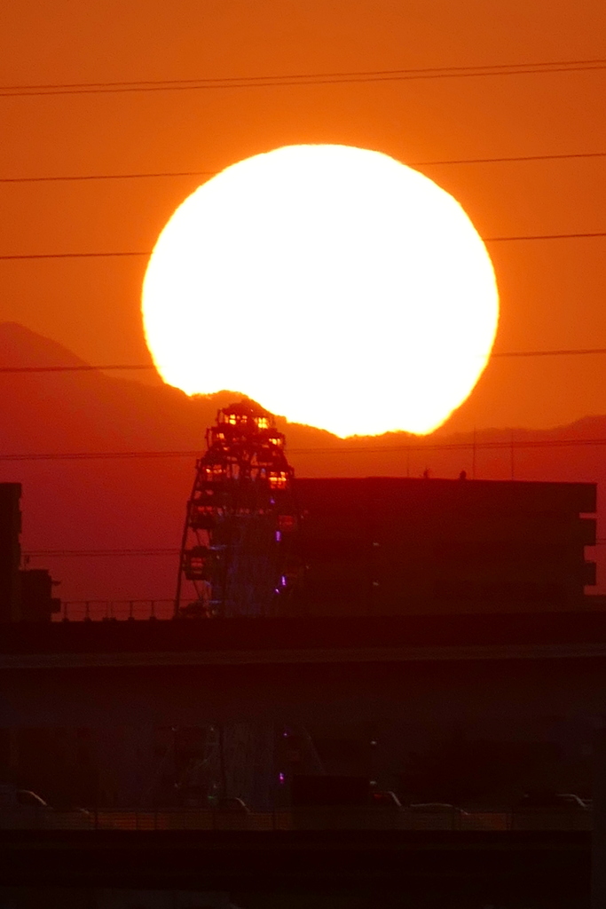 観覧車の上の大菩薩嶺右裾風張峠辺りの夕日
