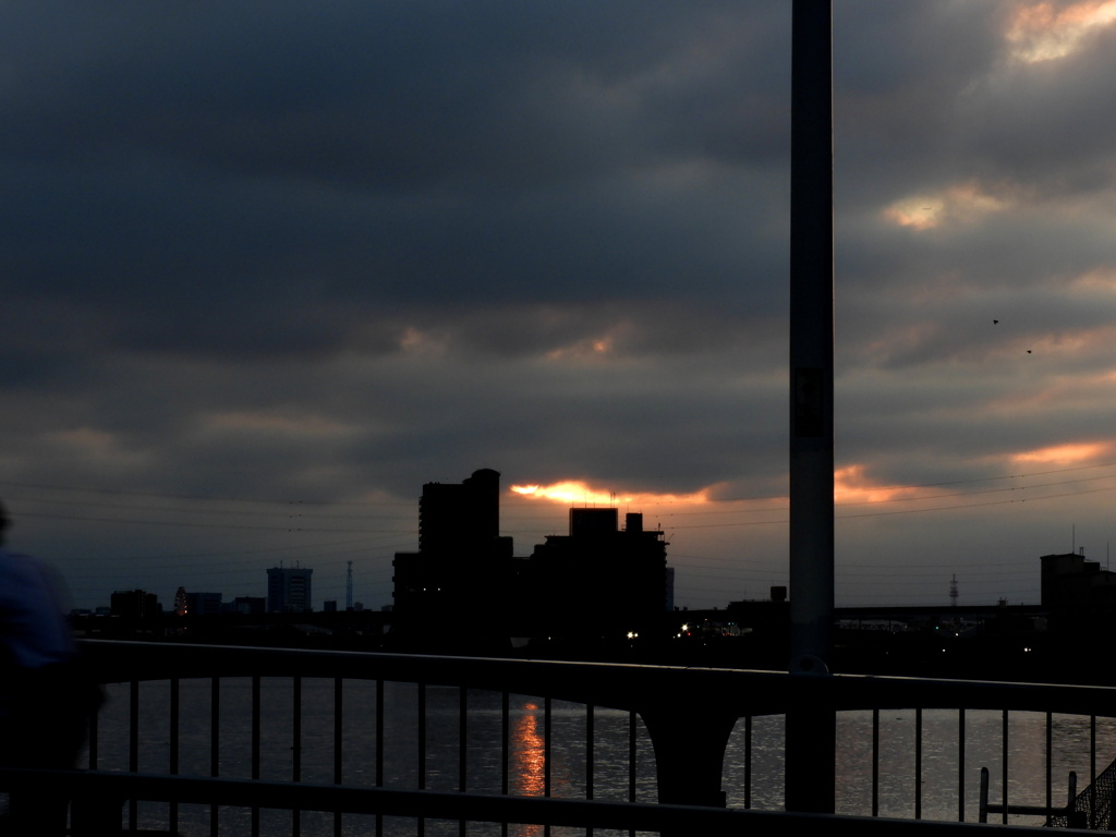 隅田川の雲間に見えた夕日光