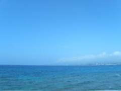 バスの車窓からのマリンブルーの沖縄の海と雲