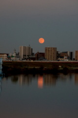 夕日が西に落ちると東から赤黄色の満月が