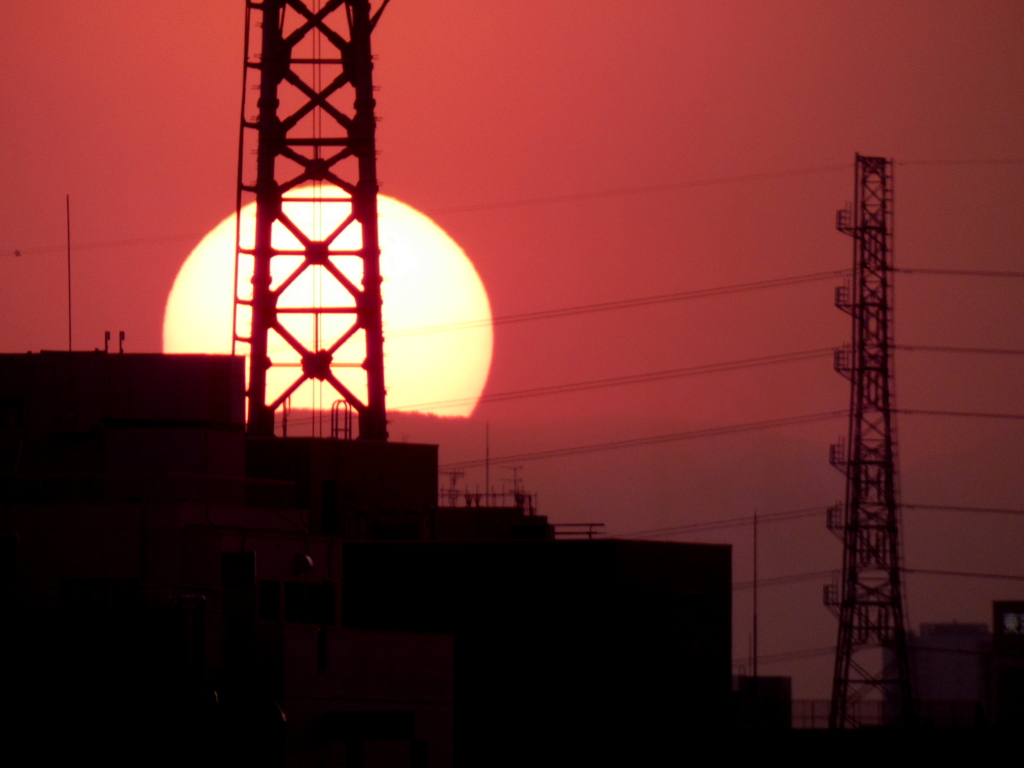 鉄塔と山と夕日の風景