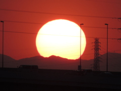 千住新橋から高速上に見えるぶな峠から南小太郎山に掛かる夕日