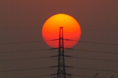 隅田川の鉄塔の大平山に接する大きな夕日