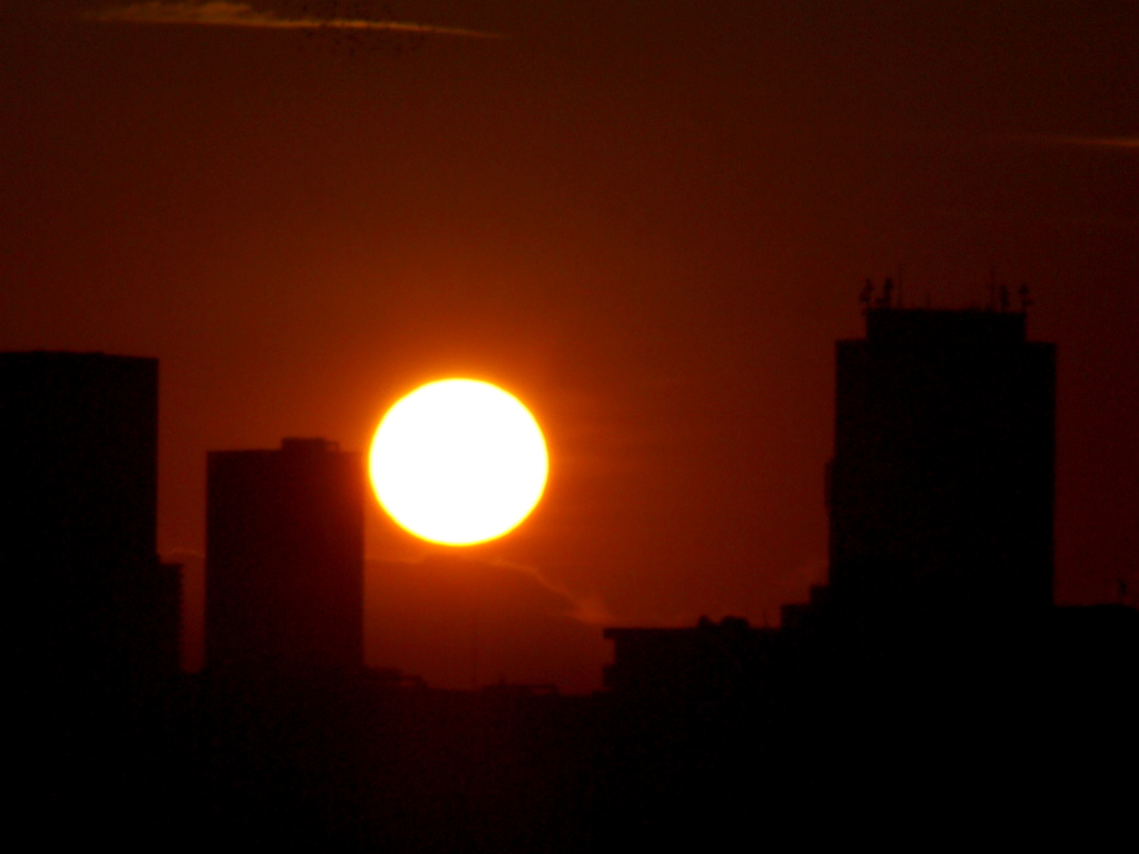 タワービルの間に見える黄金色の雲被る蛭ヶ岳山頂の夕日