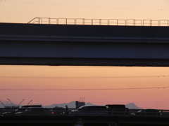 舎人ライナー高架下の扇大橋に見える夕焼けの左蕨山大持山小持山右武甲山