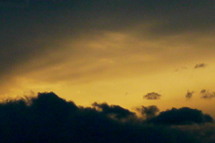 黒雲の上の金の夕焼け