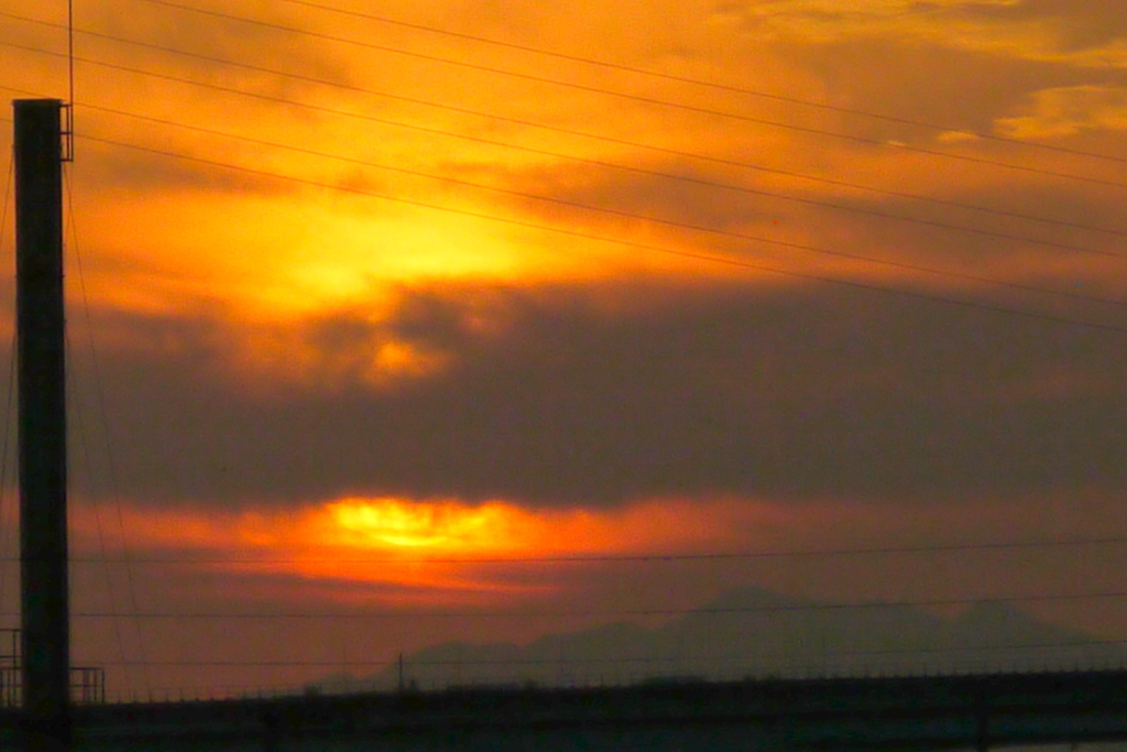 隅田川の煙突の右下のくもかぶる夕日と大持山