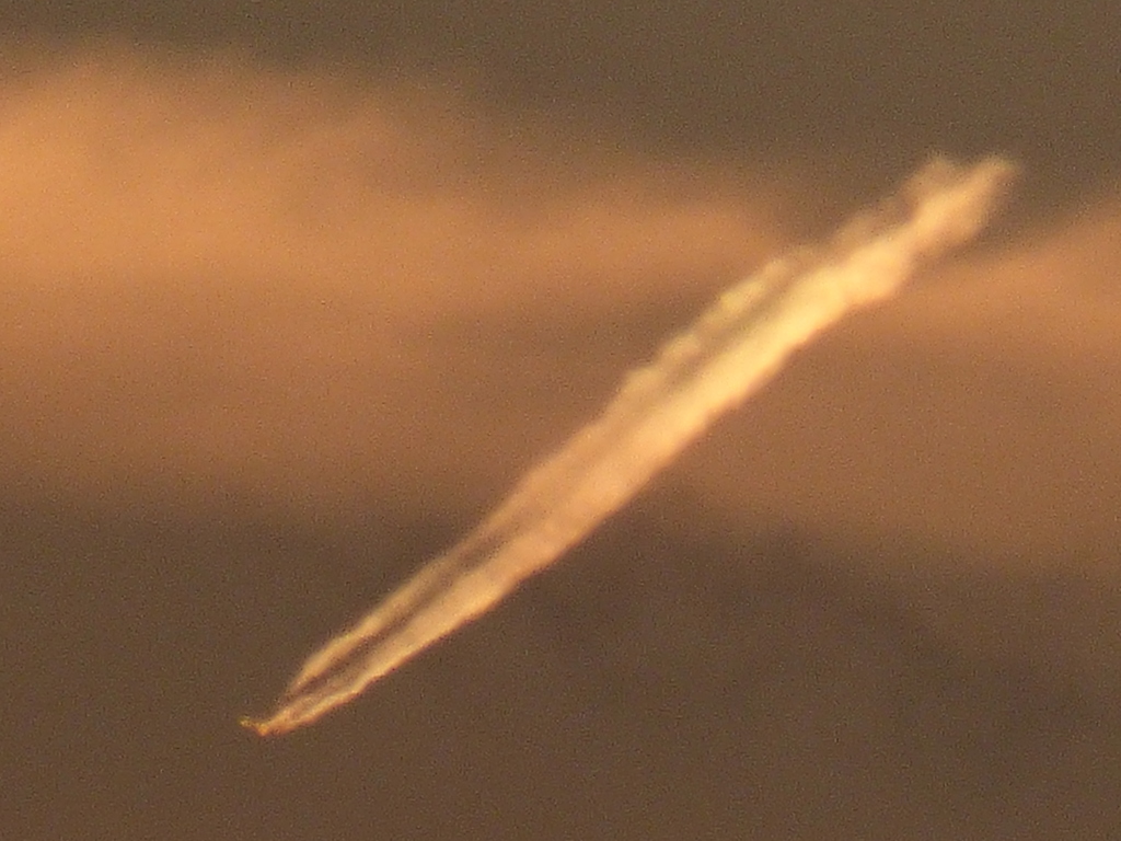 もうすでに短くなった遠方の赤い飛行機雲