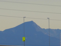 荒川土手からズームした、日を浴びる秩父の武甲山